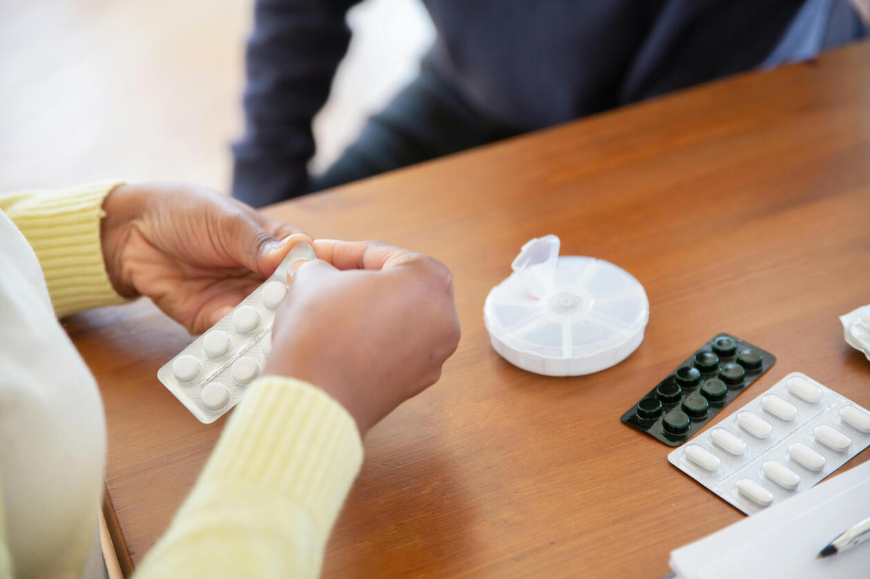 A picture of a care giver opening medicines.